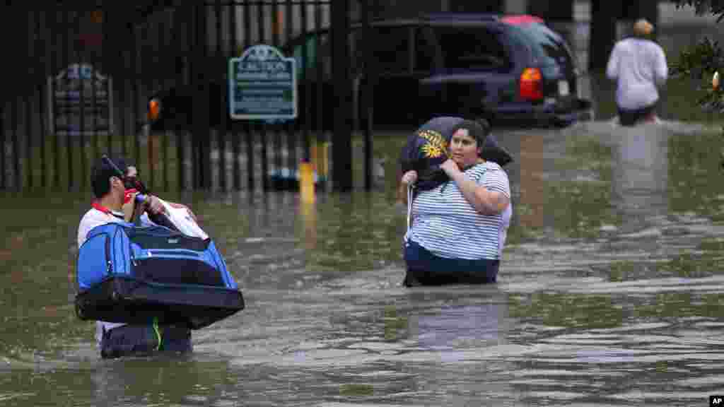 Des résidents dans les eaux après de fortes pluies à Baton Rouge, le 12 août 2016.