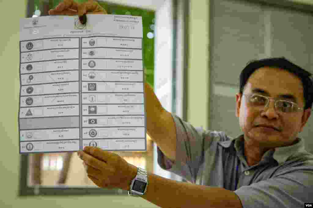 An election officer shows an invalid ballot with two big cross signs marked on it, Boeng Keng Kong 2 commune, Chamkamon district, Phnom Penh, Cambodia, Sunday, July 29, 2018. (Khan Sokummono/VOA Khmer)