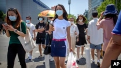 北京，人戴著口罩穿過一個十字路口（2020年6月5日）。