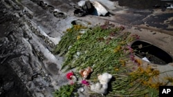 Des fleurs et des jouets déposés à l'endroit d'un accident (AP Photo/Vadim Ghirda)