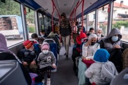 Para migran menaiki bus dalam perjalanan mereka ke Athena setelah mencoba melintasi perbatasan Yunani-Albania, di desa Mesopotamia, Yunani utara, Selasa, 28 September 2021.