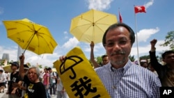 香港民主派抗议者举着黄雨伞在香港立法会外集会。（2015年6月17日）