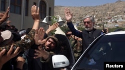 Afghan presidential candidate Abdullah Abdullah (R) waves after a ceremony commemorating the 2001 assassination of legendary Tajik resistance commander Ahmad Shah Massoud, in Kabul, Afghanistan, Sept. 9, 2014.