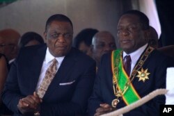 Zimbabwean President Emmerson Mnangagwa (R) sits with his Deputy Constantino Chiwenga during a Heroes' Day event to commemorate the lives of those who died in the southern African country's 1970s war against white minority rule, in Harare, Aug. 13, 2018.