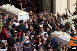 FILE - Relatives and friends carry the coffins of brothers Nadi Yousef Shehata, right, and Reda Yousef Shehata, two of the seven victims of an Islamic State ambush, in Minya, Egypt, Nov. 3, 2018.
