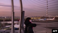 Una mujer mira desde la plataforma de observación del aeropuerto internacional Haneda de Tokio el 29 de noviembre de 2021.