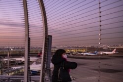 Seorang wanita di bandara internasional Haneda Tokyo pada 29 November 2021, ketika Jepang mengumumkan rencana untuk melarang semua pelancong asing baru menggunakan varian omicron. (Foto: AFP/Philip Fong)