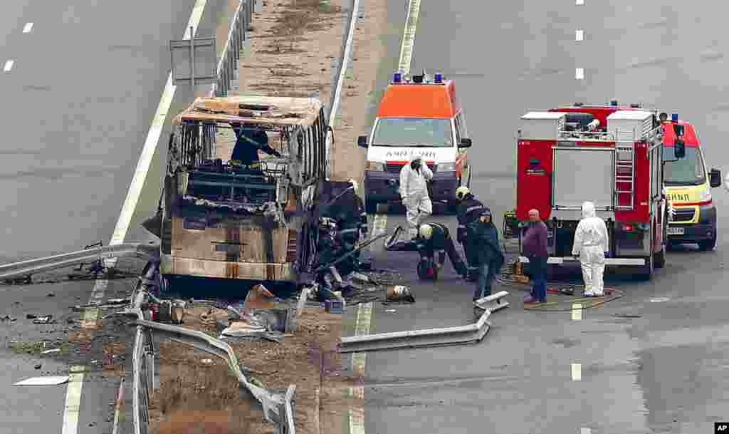 Firefighters and forensic workers inspect the scene of a bus crash on a highway near the village of Bosnek, western Bulgaria.