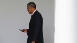 In this file photo, President Barack Obama checks his Blackberry smartphone upon his return from a trip to New York, as he walks into the West Wing of the White House in Washington, May 15, 2014. REUTERS/Jim Bourg