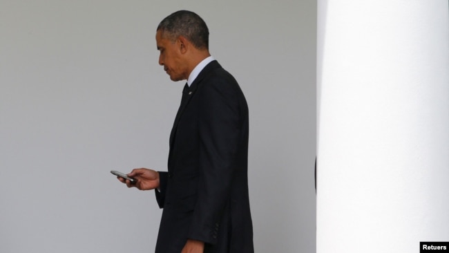 In this file photo, President Barack Obama checks his Blackberry smartphone upon his return from a trip to New York, as he walks into the West Wing of the White House in Washington, May 15, 2014. REUTERS/Jim Bourg