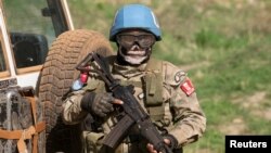 FILE - A United Nations peacekeeping soldier provides security during a food aid delivery by the United Nations Office for the Coordination of Humanitarian Affairs and World Food Program in the village of Makunzi Wali, Central African Republic, April 27, 2007.