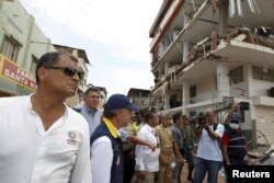 Ecuadorian President Rafael Correa (L) and his Colombian counterpart Juan Manuel Santos (2nd L) gesture as they visit Manta, after an earthquake struck off Ecuador's Pacific coast, April 24, 2016.