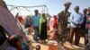 FILE - Somalia Conflict takes toll on civilian mental health. A Somali soldier provides security as newly displaced Somalis gather at a camp on the outskirts of Mogadishu, Somalia, March 28, 2017. 