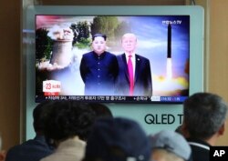 FILE - People watch a TV screen showing file footage of U.S. President Donald Trump, right, and North Korean leader Kim Jong Un during a news program at Seoul Railway Station in Seoul, South Korea, June 11, 2018.