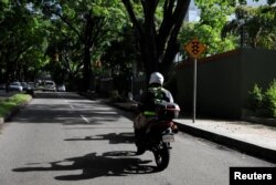 An employee of Pana, a mobile application which dispatches security crews to stranded drivers who request help, rides a motorbike on his way to assist a client in Caracas, Venezuela, June 15, 2018.
