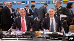 FILE - NATO Secretary General Jens Stoltenberg, right, and Montenegro's Prime Minister Milo Dukanovic, left, take their seats during a meeting of the North Atlantic Council and Montenegro at NATO headquarters in Brussels, May 19, 2016.