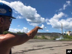 Brian Weekly, a contractor at West Virginia’s Grant Town coal-fired power plant, gestures toward the small facility’s smokestack, Aug. 23, 2018 in Grant Town.