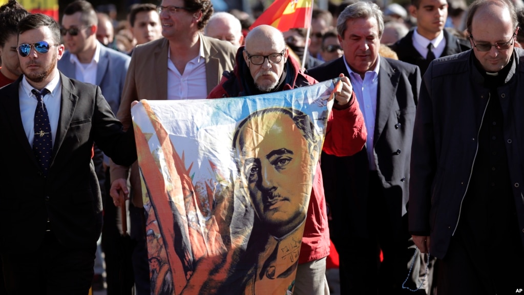 Мужчина держит изображение диктатора Франсиско Франко во время собрания у кладбища Мингоррубио, где сейчас покоится Франко, на окраине Мадрида. 