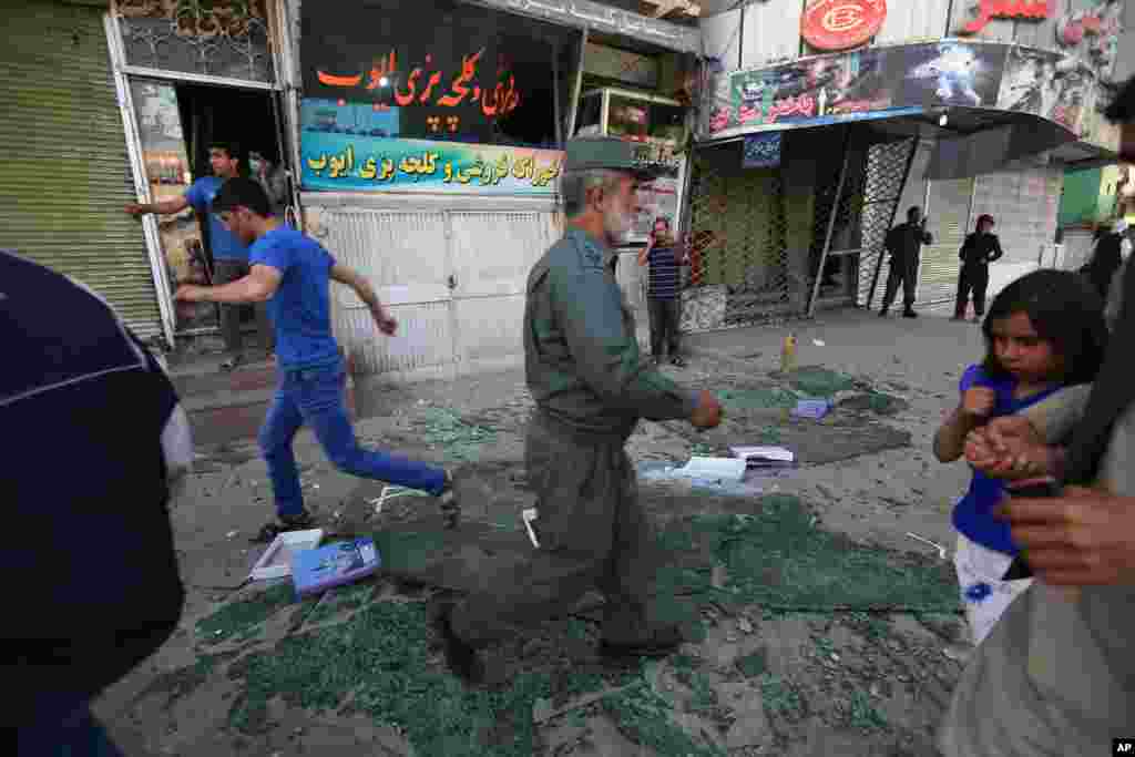 A member of the Afghan security forces walks over broken glass after a suicide car bombing attack in Kabul, &nbsp;May 19, 2015.