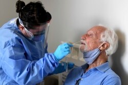 NIH funded Moderna COVID-19 vaccine study participant William Webb, right, gets a COVID-19 test nose swab by University of Miami Miller School of Medicine nurse Loreta Padron, Wednesday, September 2, 2020 in Miami.