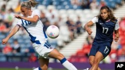 Camille Abily, izquierda, de Francia, intenta tapar el disparo de Tobin Heath, de Estados Unidos, durante el juego del grupo G, en que las estadounidenses derrotaron a las francesas, 4-2.