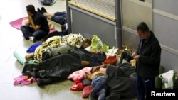 Migrants sleep in the hall of main railway station in Munich, Germany, Sept. 13, 2015.