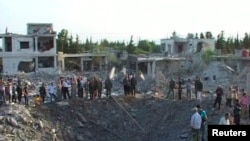 Sirijci okupljeni oko kratera u gradu Hama koji je napravila eksplozija