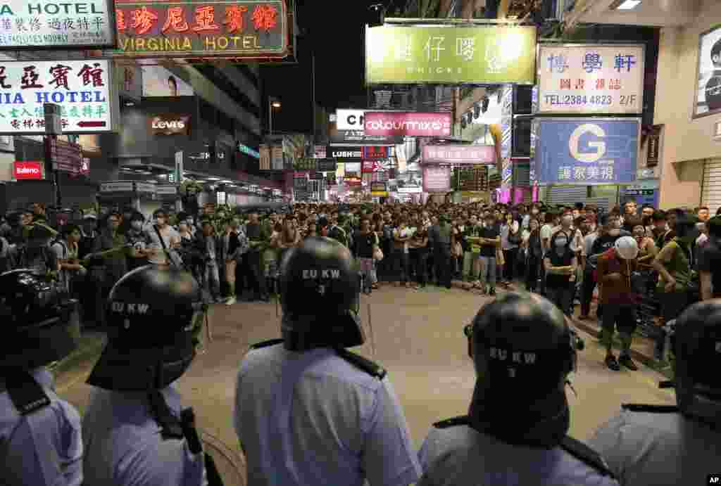 Riot police officers stand guard at a main road in the Mong Kok district of Hong Kong, Oct. 17, 2014. New scuffles broke out Friday night between police and pro-democracy activists in district where police cleared protesters earlier in the day.