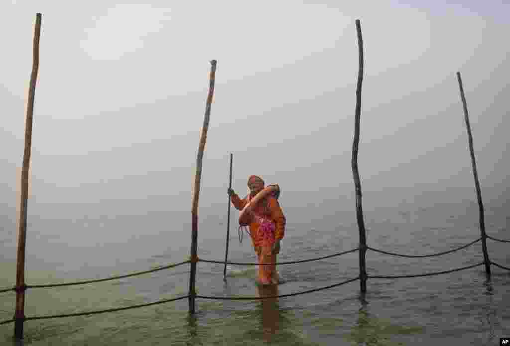 Seorang relawan Hindu sambil membawa pelampung, mengamati batas sungai Sangam bagi festival Mandi Agung Kumbh Mela di kota Allahabad, India (14/1).