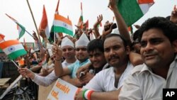 Supporters of anti-corruption activist Anna Hazare wave Indian national flags during Hazare's fast at Ramlila Grounds in New Delhi on August 22, 2011