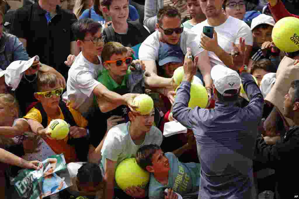 Spain&#39;s Rafael Nadal and his security guard, right, ask fans to calm down to prevent children from getting crushed after Nadal&#39;s second round match of the French Open tennis tournament against Germany&#39;s Yannick Maden at the Roland Garros stadium in Paris.