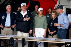 President Donald Trump, first lady Melania Trump and Vice President Mike Pence, left, participate in a briefing on the Hurricane Irma relief efforts, Sept. 14, 2017, in Ft. Myers, Fla., after arriving at Southwest Florida International airport.