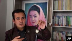 Hameed Rafi holds his sister's watch during an interview with the Associated Press at the Rahila library, in Kabul, Afghanistan. (AP Photo) 