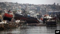 Boats lifted by an earthquake-triggered tsunami sit on a dock, in Coquimbo, Chile, Sept. 18, 2015. 