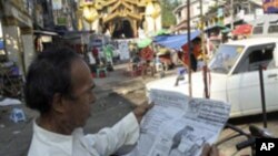 A trishaw man reads a newspaper reporting elections as he awaits passengers on Monday, Nov. 8, 2010, in Yangon, Myanmar. Myanmar's secretive military-ruled government gave no sign Monday of when results from the country's first election in two decades wou