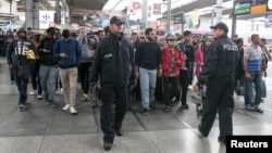 Migrants walk after arriving by train to the main railway station in Munich, Germany, Sept. 6, 2015. 