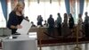 A woman casts her ballot as voters line up at a polling station during parliamentary elections in Minsk, Belarus, Sept. 11, 2016.