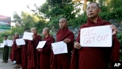 Buddhist monks hold banners reading "OIC Get Out" as they protest against the arrival of a delegation from the Organization of Islamic Cooperation, at the airport in Rangoon, Burma, Nov. 13, 2013.