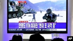 South Koreans watch a live TV breaking news about South Korea's live fire artillery at Seoul train station in Seoul, 20 Dec 2010