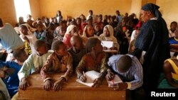 Children listen to a school teacher after the reopening of Mahamane Fondogoumo elementary school in the town center of Timbuktu, Mali, February 1, 2013.