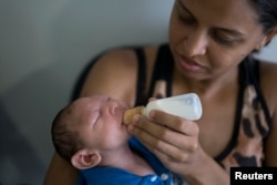 Daniele Ferreira dos Santos feeds her son Juan Pedro, who suffers from microcephaly, as they wait to be examined at the Altino Ventura Foundation, a treatment center that provides free health care, in Recife, Pernambuco state, Brazil, Feb. 4, 2016.