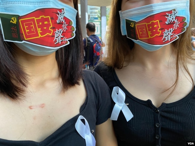 香港市民I小姐及T小姐在口罩上贴上反对港牌国安法的标语，呼吁香港人发挥流动文宣的创意。 (美国之音/汤惠芸)