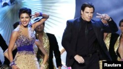 Aktris Bollywood Priyanka Chopra menari dengan bintang Hollywood John Travolta dalam 15th International Indian Film Academy Awards di Tampa, Florida, April 2014. (Reuters/Mohammed Jaffer-SnapsIndia)