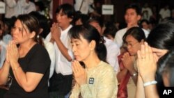 Burma's democracy icon Aung San Suu Kyi, center, and members of her National League for Democracy Party (NLD) pay respects to Buddhist monks during the 23rd anniversary of the 1988 uprising that was brutally crushed by Burma's military, at a monastery on 