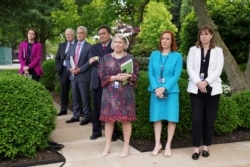 White House Press Secretary Jen Psaki, Communications Director Katherine Bedingfield and other staff members stand without protective face masks at the Rose Garden of the White House in Washington, U.S., May 13, 2021. (REUTERS/Kevin Lamarque)