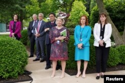 White House Press Secretary Jen Psaki, Communications Director Katherine Bedingfield and other staff members stand without protective face masks at the Rose Garden of the White House in Washington, U.S., May 13, 2021. (REUTERS/Kevin Lamarque)