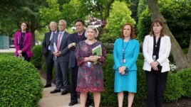 White House Press Secretary Jen Psaki, Communications Director Katherine Bedingfield and other staff members stand without protective face masks at the Rose Garden of the White House in Washington, U.S., May 13, 2021. (REUTERS/Kevin Lamarque)