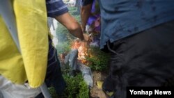 12일 서울 종로구 주한 일본대사관 앞에서 최모 씨가 분신을 시도해 수요집회 참가자들이 불을 끄고 있다.