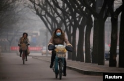 北京雾霾笼罩，行人上街带着口罩。（资料照片）
