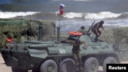 FILE - Russian navy personnel are seen disembarking from an armored personnel carrier (APC) in Kaspiysk, Russia, Aug. 5, 2015.